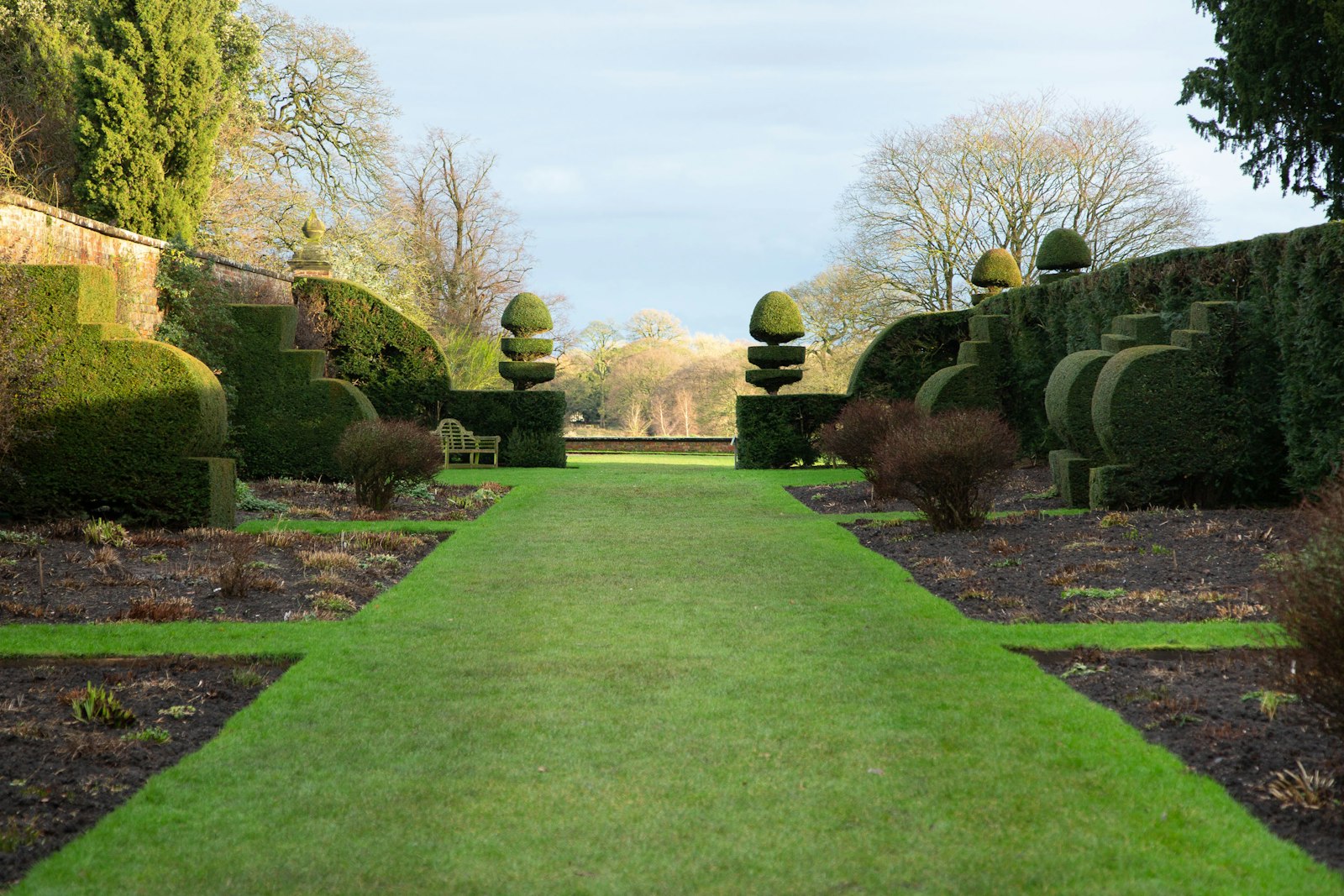 Long manicured green lawn under mature oak trees.